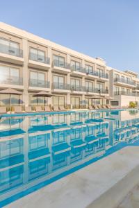 um edifício com uma piscina em frente em Samian Mare Hotel, Suites & Spa em Karlovasi