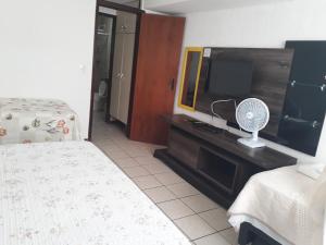 1 dormitorio con TV, 1 cama y ventilador en Atlântico flat 214, en Natal 39 fotos más