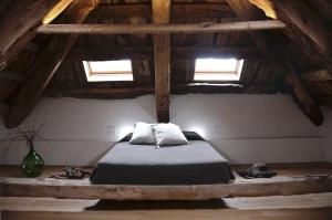 a bedroom with a bed in a wooden attic at Relais Poggio Pagnan in Farra