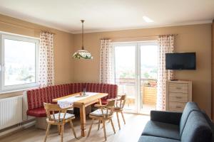 a living room with a couch and a table and chairs at Gailtal Panorama in Kötschach