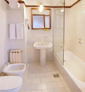 W łazience znajduje się toaleta, umywalka i prysznic. w obiekcie Bremen Hotel & Spa w mieście Villa General Belgrano