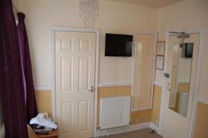 a room with a door and a tv on the wall at Compton House in Ashbourne