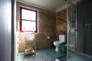 a bathroom with a toilet and a glass shower at Casa do Lonho in Arouca +25 photos