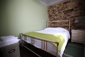 a bedroom with a bed and a stone wall at Casa do Lonho in Arouca
