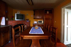 a kitchen with a wooden table and a fireplace at Casa do Lonho in Arouca