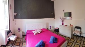 1 dormitorio con 1 cama rosa y 2 sillas en Casa Sabrina, en Lipari
