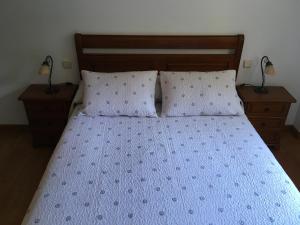 a bedroom with a bed with two night stands and two lamps at Bizentenea in Zugarramurdi