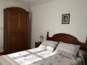 1 dormitorio con 1 cama y armario de madera en Bizentenea, en Zugarramurdi