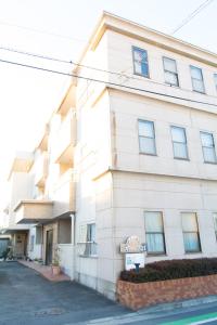 a white building with a street in front of it at Mark's HOME in Maebashi