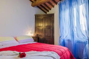 Un dormitorio con una cama con una rosa roja. en Le Casette Country House 2, en Petricci