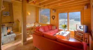 sala de estar con sofá rojo y chimenea en Chalet Bois - Chamonix, en Chamonix-Mont-Blanc