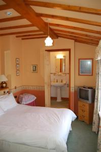 - une chambre avec un lit, un lavabo et une télévision dans l'établissement Compton House, à Ashbourne