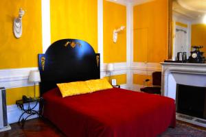 1 dormitorio con 1 cama con manta roja y chimenea en Hotel Windsor Home en París