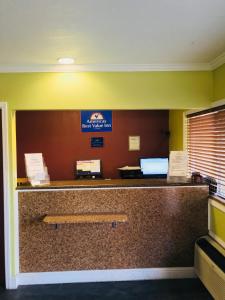 Americas Best Value Inn Visalia في فيساليا: غرفة انتظار مع كونتر مع مقاعد