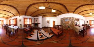 una grande stanza con tavoli, sedie e un camino di Posta del Sol a Maimará
