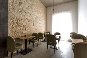 a dining room with tables and chairs and a wall at La Puerta de Palacio - Adults Only in Seville