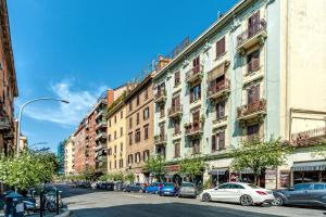 a city street with cars parked in front of buildings at SmooRoomS Roma Ostiense in Rome