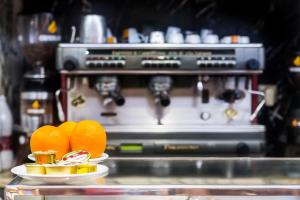 eine Kaffeemaschine mit Orangen auf Tellern auf der Theke in der Unterkunft Hotel Residencia Castellano I in Salamanca