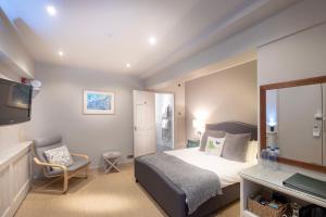 a bedroom with a bed and a mirror and a chair at Edgar Townhouse in Bath