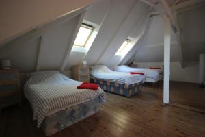 two beds in a room with two windows at La Maison de Beauport in Paimpol