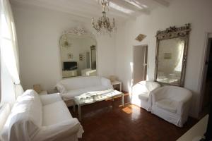 a living room with white furniture and a mirror at La Maison de Beauport in Paimpol