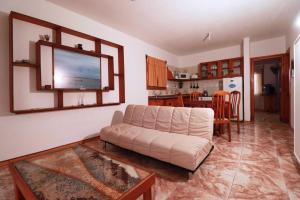 Una sala de estar con un sofá y una cocina. en Apartamentos lo de Renan, en La Paloma