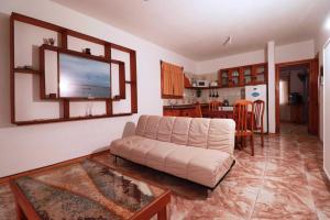 sala de estar con sofá y cocina en Apartamentos lo de Renan, en La Paloma