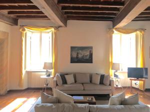 a living room with a couch and two windows at La casa dell'Arte nel cuore di Roma in Rome