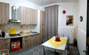uma cozinha com uma mesa e uma pequena cozinha com uma mesa e cadeiras em Casa Sabrina em Lipari