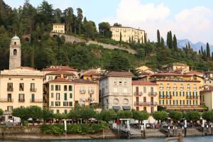 eine Gruppe von Gebäuden auf einem Hügel neben dem Wasser in der Unterkunft palazzo barindelli suite bianca in Bellagio