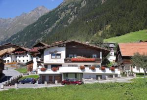 a large white building with flowers on the balcony at Alpenheim Mathias in Sölden