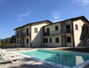 a villa with a swimming pool in front of a building at Casa Elena in Camporgiano