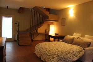a bedroom with a bed and a spiral staircase at Il Fienile, casa vacanza in campagna con parcheggio privato e giardino privato, a 6 chilometri da Bologna centro e 1 chilometro da Bologna Fiera, Parco commerciale Meraville e Gran Tour Italia in Bologna