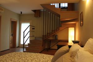 a living room with a staircase and a bed at Il Fienile, casa vacanza in campagna con parcheggio privato e giardino privato, a 6 chilometri da Bologna centro e 1 chilometro da Bologna Fiera, Parco commerciale Meraville e Gran Tour Italia in Bologna