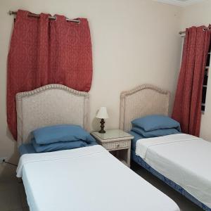 two beds in a room with red curtains at 1002 Crystal Court Condominiums in Saint James