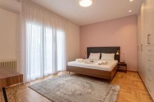 アテネにあるExquisite HiEnd 3bdr 4th flr Top Kolonaki spotのベッドルーム1室(ベッド1台、大きな窓付)
