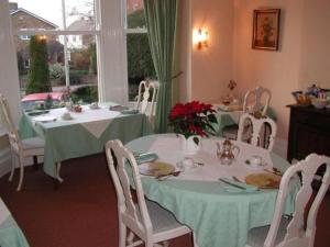 チェルトナムにあるBadger Towersのダイニングルーム(テーブル2台、椅子付)、窓