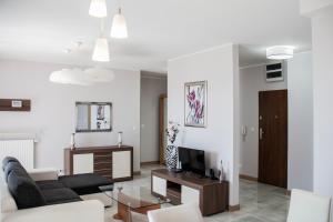Televízia a/alebo spoločenská miestnosť v ubytovaní Senator Warsaw Apartments