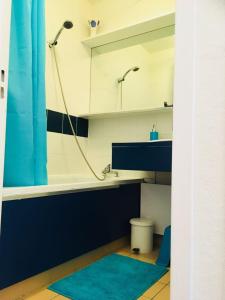 baño con lavabo y ducha con cortina azul en Studio face à la mer +terrasse+ parking, en Canet-en-Roussillon