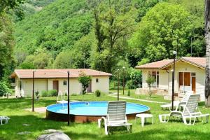 a yard with a pool with chairs and a house at Hotel Valdis in Pastra