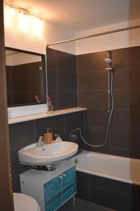 La salle de bains est pourvue d'un lavabo et d'une baignoire. dans l'établissement Schöne EinZimmer Wohnung Zwischen Bodensee und Allgäu, à Neukirch