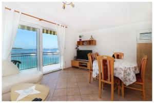 a living room with a table and a couch and a television at Apartmani Petra in Primošten