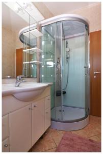 La salle de bains est pourvue d'une douche et d'un lavabo. dans l'établissement Apartmani Petra, à Primošten