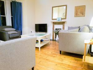 a living room with two couches and a tv at Big, Beautiful, Cosy Falmouth House in Falmouth