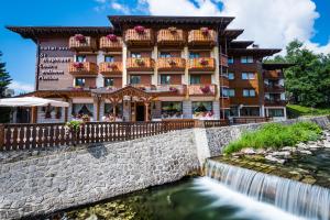 a hotel with a waterfall in front of a building at Hotel St. Raphael in Madonna di Campiglio