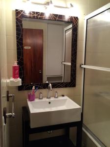 a bathroom with a sink and a mirror and a shower at Playa Club in Miramar