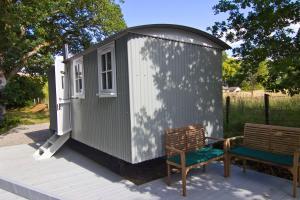 a small shed with two benches on a deck at Riverside Bothy at Allt A'Mhuilinn in Spean Bridge