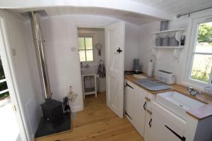 a kitchen with a stove in the middle of it at Riverside Bothy at Allt A'Mhuilinn in Spean Bridge