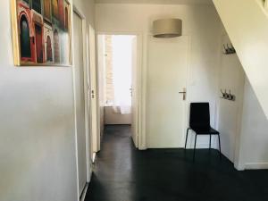 a hallway with a black floor and a chair at CosyStudio2 Site du Futuroscope in Jaunay-Marigny