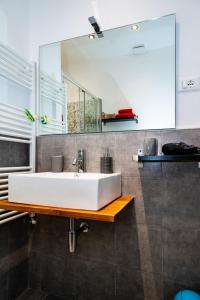 uma casa de banho com um lavatório branco e um espelho. em shelley affittacamere em La Spezia